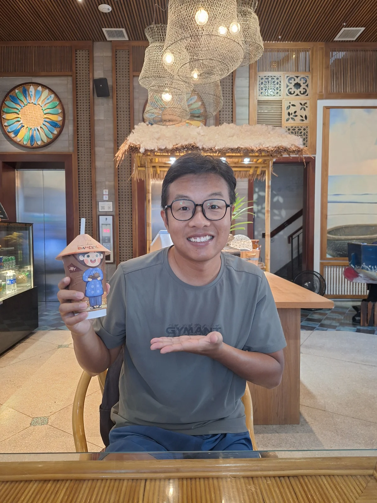 Edward smiling with a drink at a cafe in Da Nang.