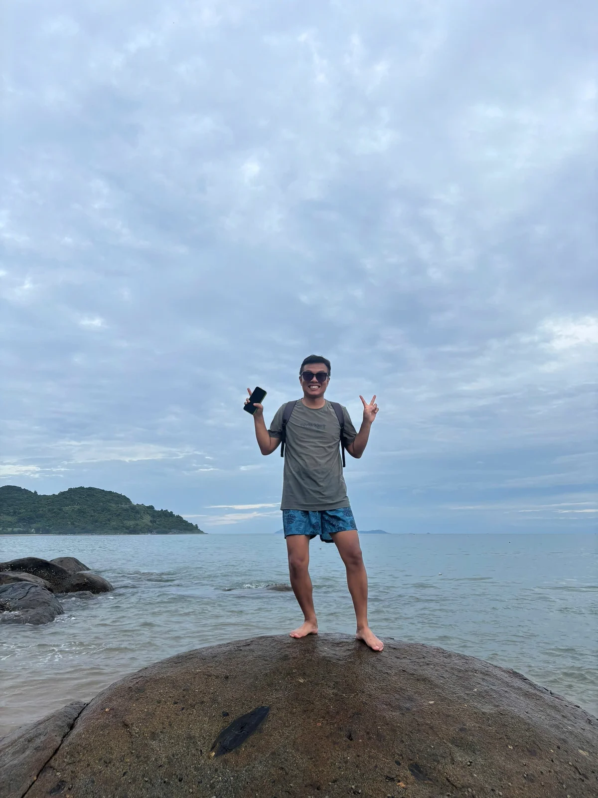Edward standing on coastal rocks with the ocean behind him.
