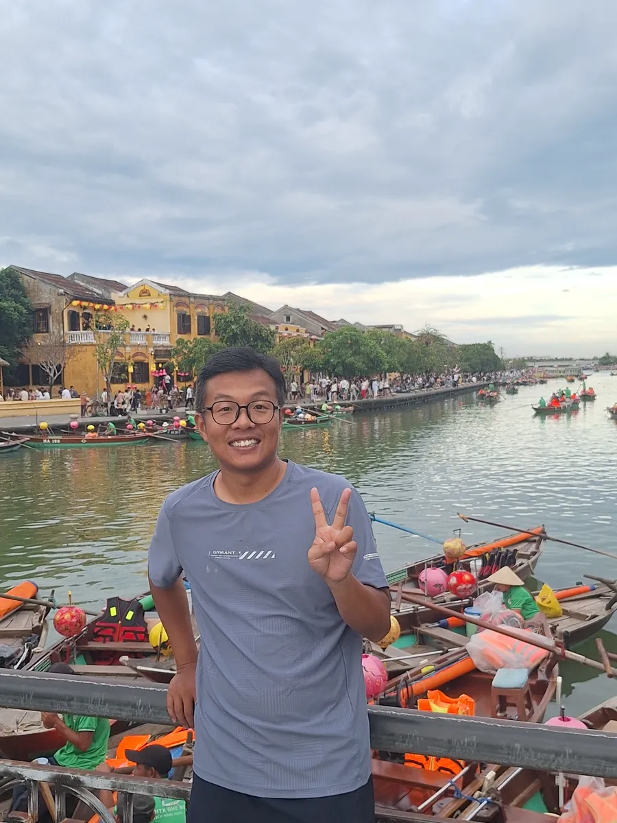 Edward smiling on a boat during a riverside trip.