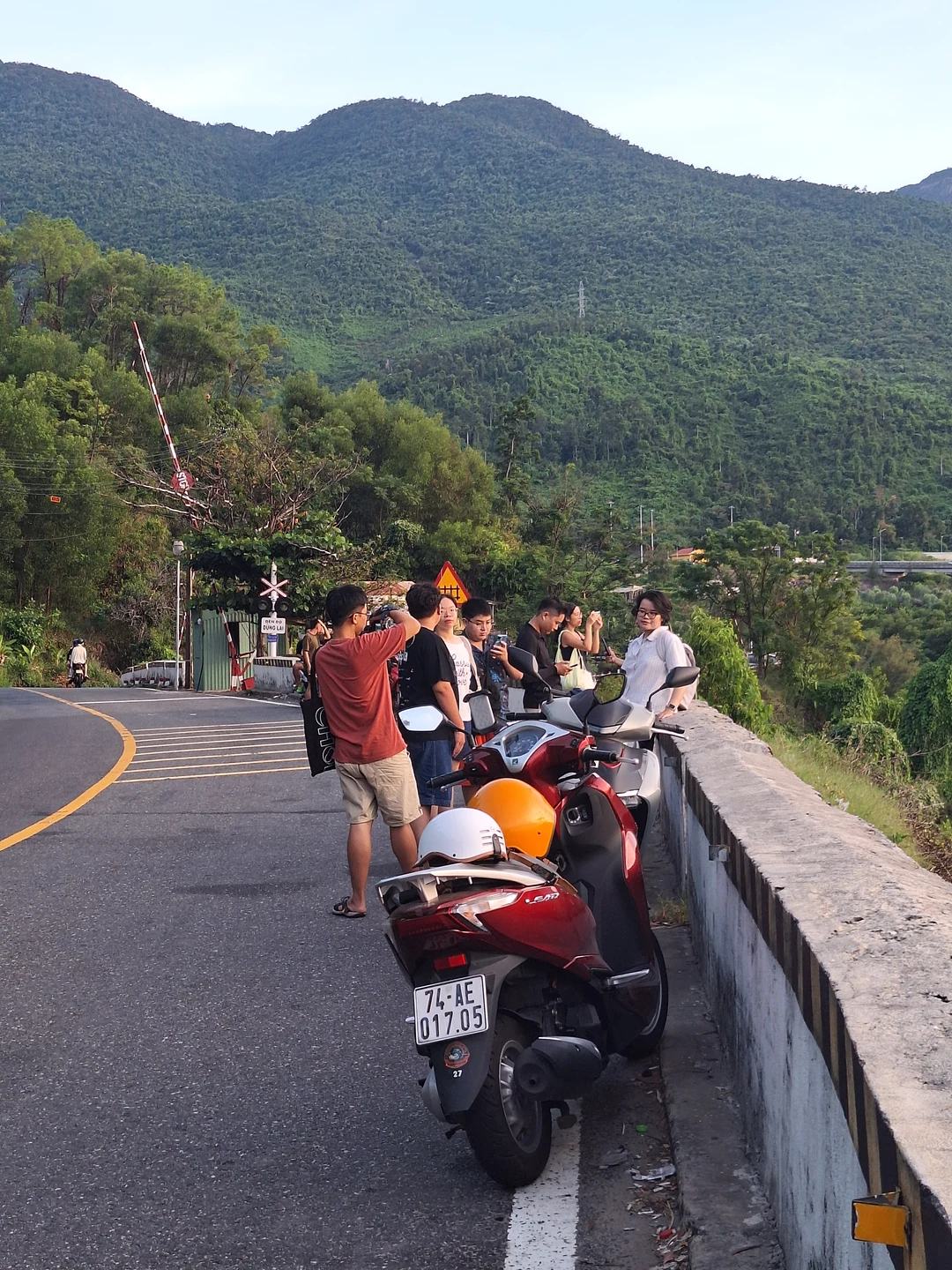 Conquering the Hai Van Pass · Winding mountain coastal road with parked motorbikes overlooking lush green peaks