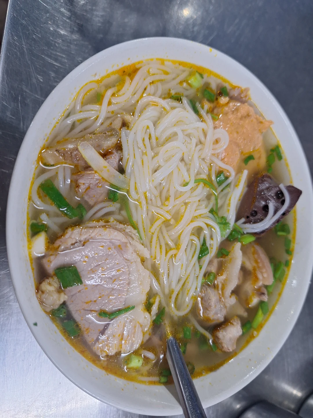 Authentic Bun Bo Hue · Steaming spicy lemongrass beef broth served with round rice noodles