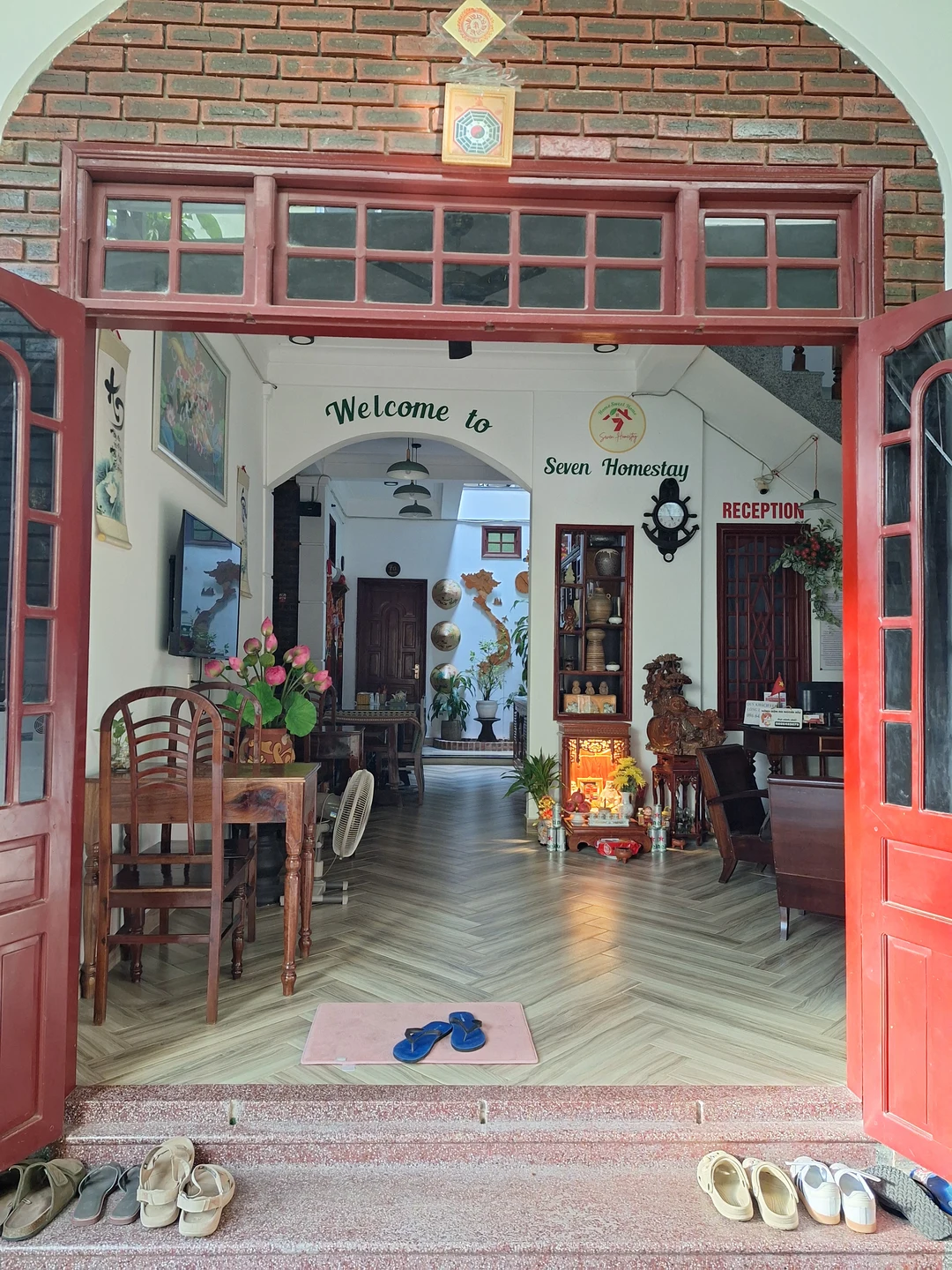 Traditional Hue Courtyard Homestay · Lush foliage framing weathered wooden architecture