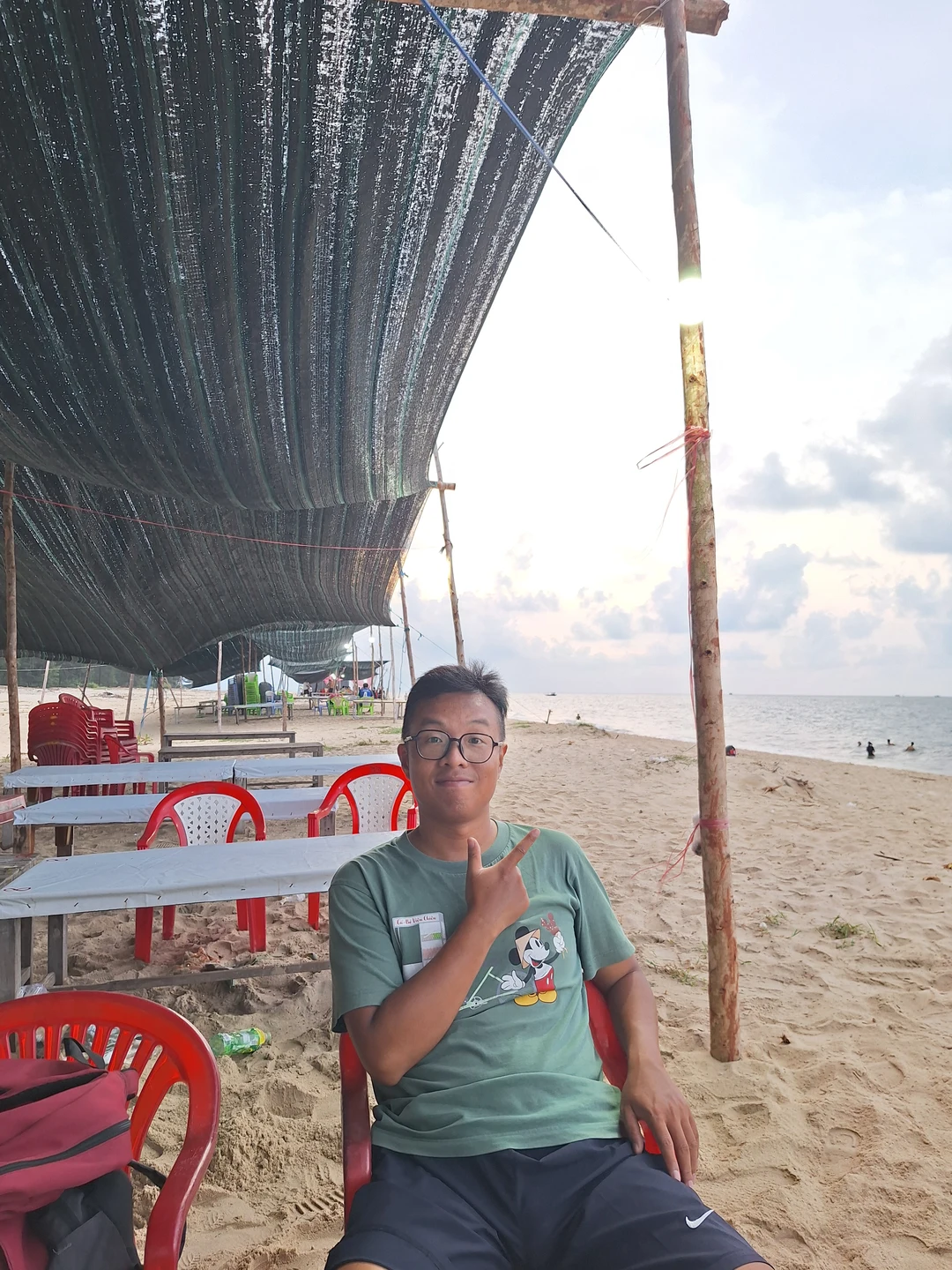 Relaxing under the Awning at Thuan An Beach · Unwinding in red plastic chairs on quiet sands