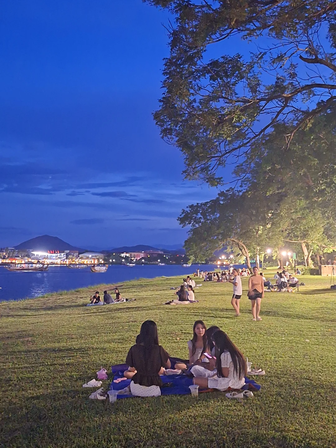 Deepening Twilight along Perfume River · Evening boat lights reflecting on water